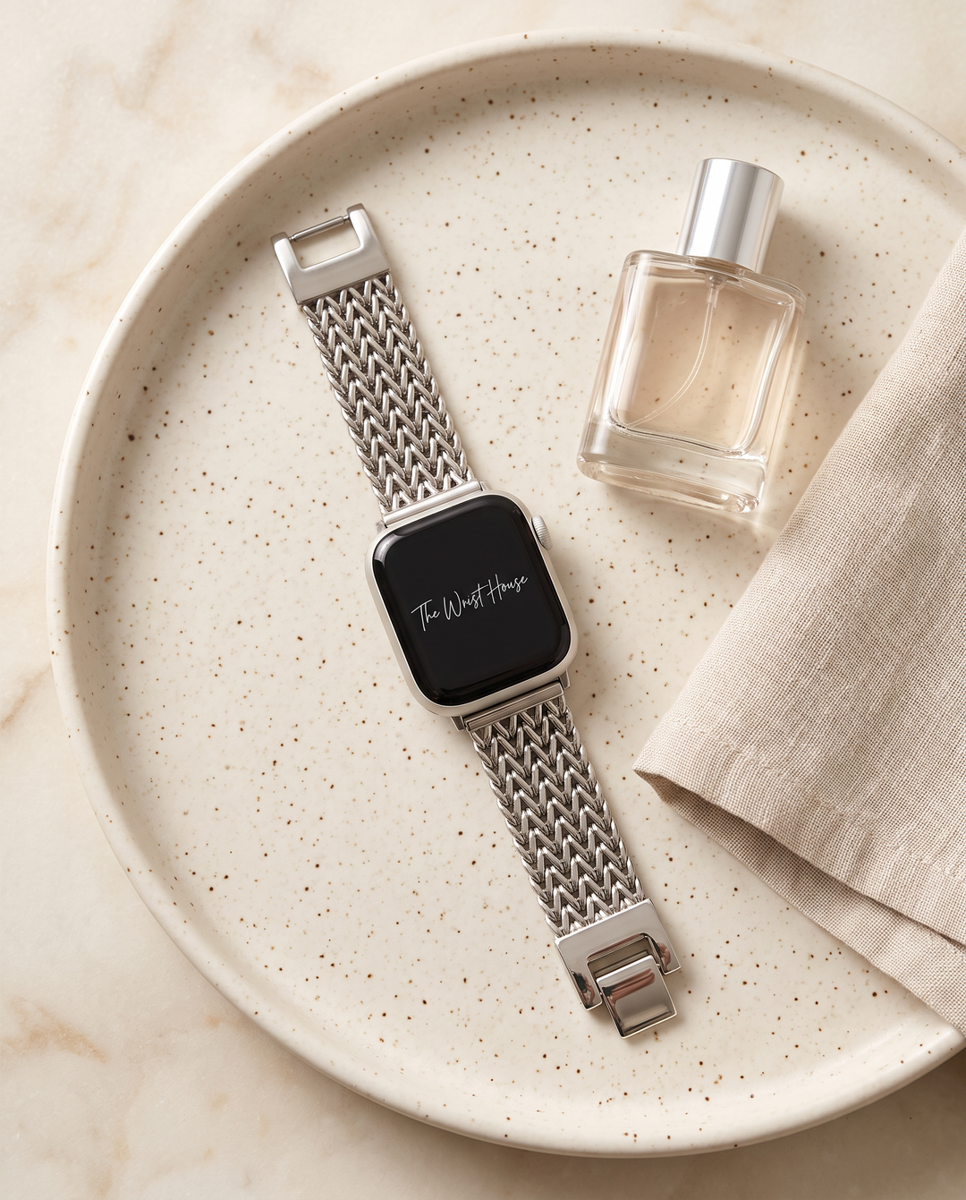 Silver chain band for Apple Watch on a ceramic tray