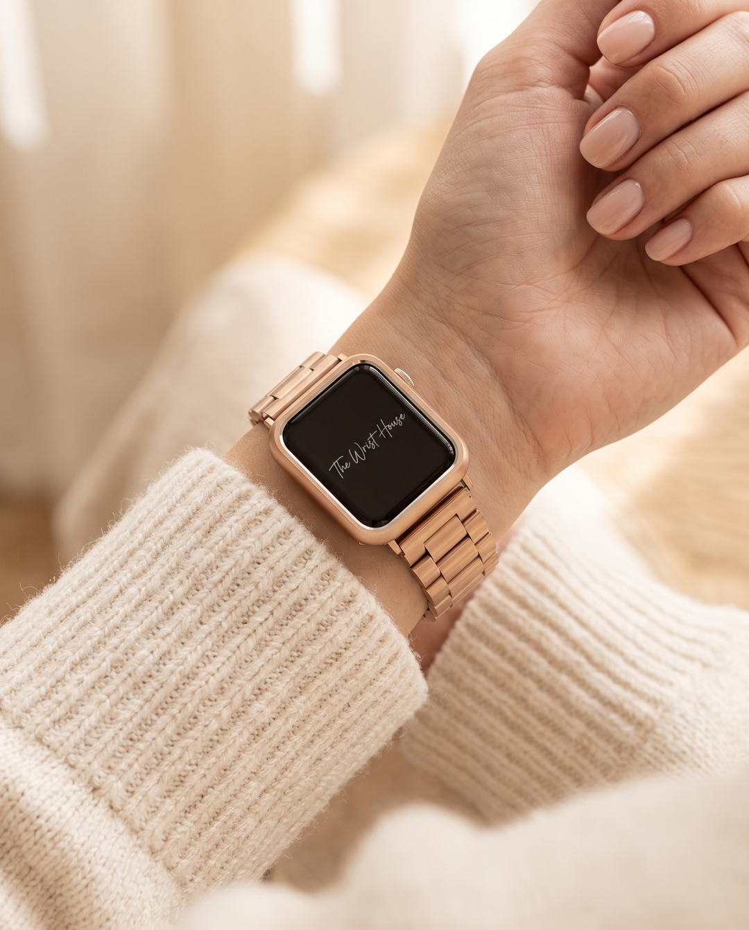 Rose gold 3-link Apple Watch band worn on a woman's wrist